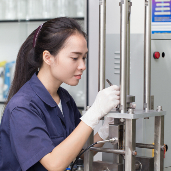 metallurgical-tensile-testing-services Technician performing metallurgical tensile testing in a laboratory environment.